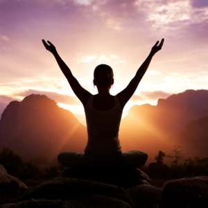 silhouette of woman doing yoga outdoors