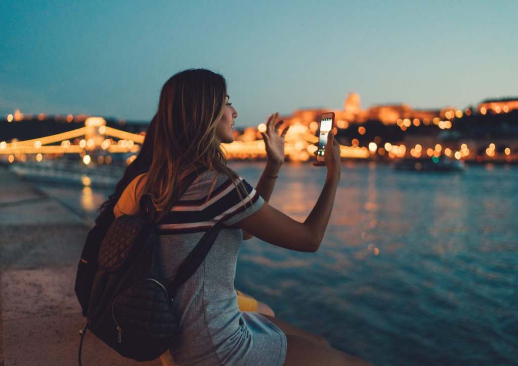 Tourist in Budapest taking photos with smartphone