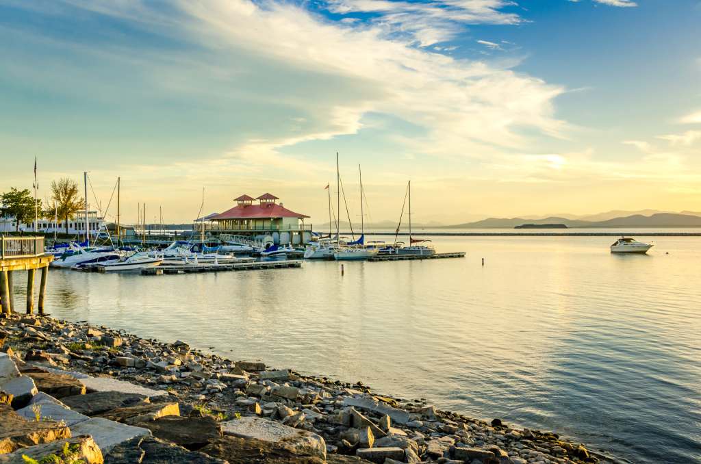 The harbor at sunset in Burlington, Vermont. Burlington is known for its local charm, bustling arts scene, live music, and cozy cafes. 