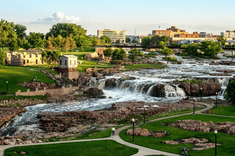 Top Bucket List Things To Do During Your South Dakota Assignment overlook of a park and city featuring a waterfall and tower in South Dakota