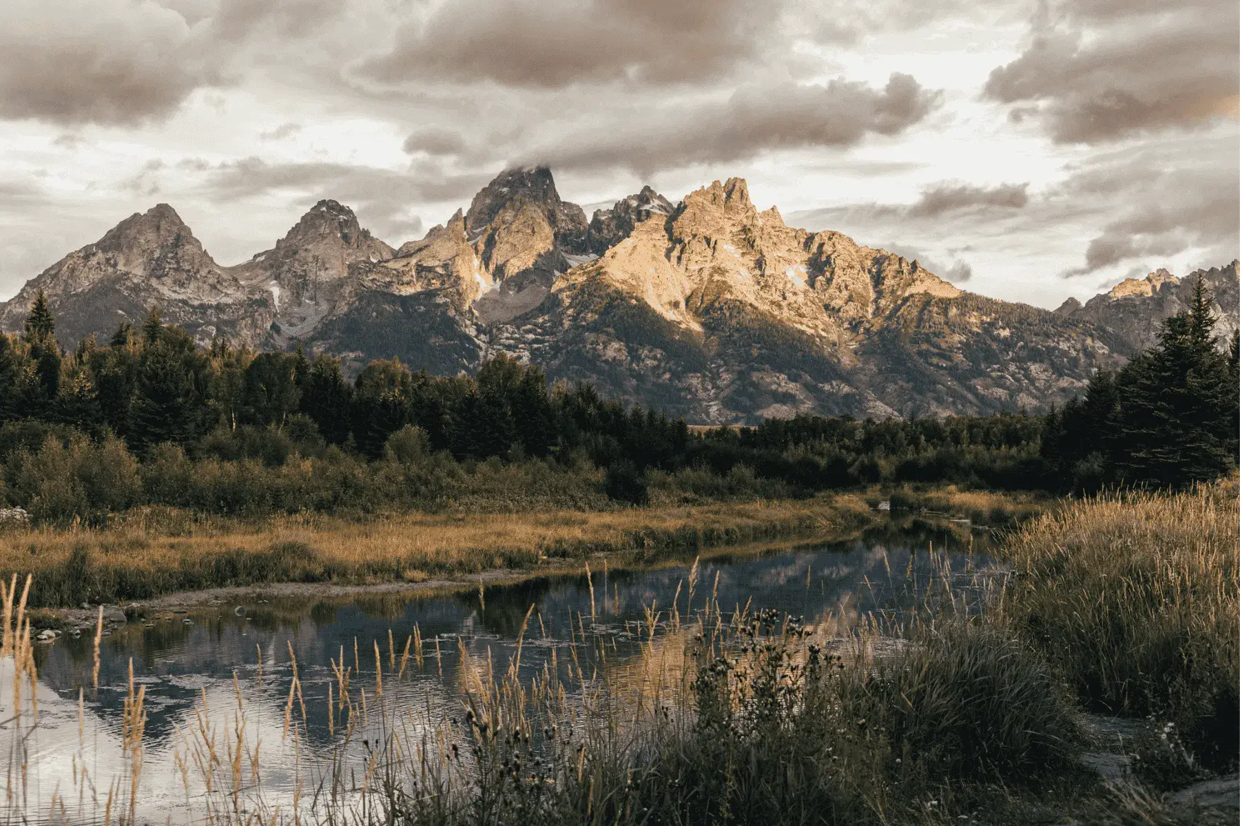 a view of a mountain range during sunrise with a river flowing below